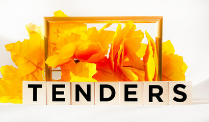 Tenders symbol. Concept word Tenders on wooden cubes. Beautiful orange background with succulent...
