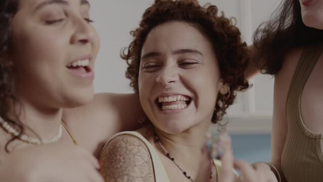 Amigas felizes,comendo brigadeiro na cozinha e se abracando. Cinematico 4k.