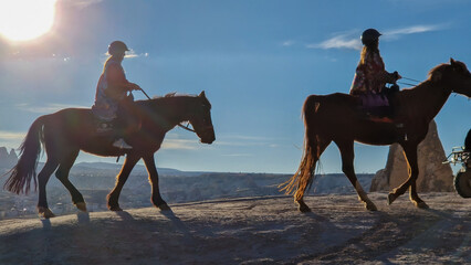 Silhouettes of two horses gracefully galloping through the mystique of Red Valley.