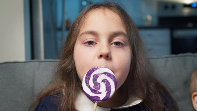 Child with lollipop happy little girl eating sugar lollipop, child eating sweets