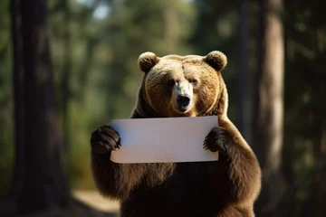 Fotobehang Bear holding a banner protesting against deforestation and destruction of wild life natural habitat © pilipphoto