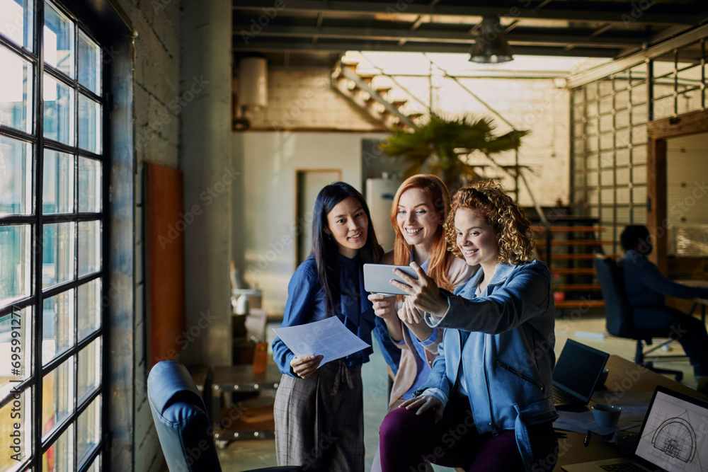 Wall mural young business women taking selfie in the office