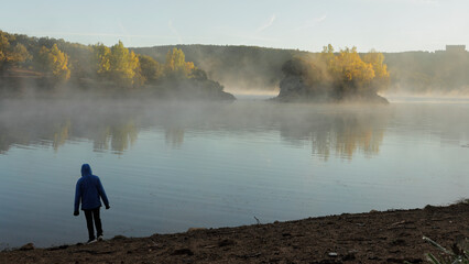 silhouette in front of a misty lake