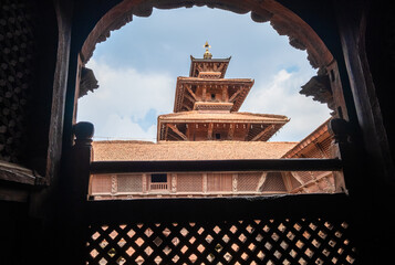 Real architecture masterpiece old temple view through the carved wood window, Patan Durbar Square...