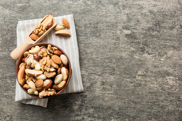 mixed nuts in bowl. Mix of various nuts on colored background. pistachios, cashews, walnuts,...