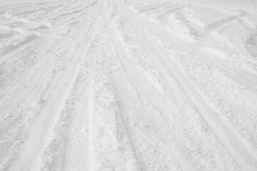 snowy road and car wheel marks in winter