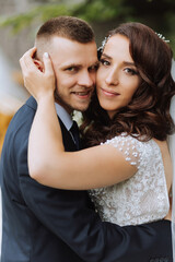Naklejka premium Wedding. Love and couple in garden for wedding. Celebrating the ceremony and commitment. Save the date. Trust. The groom embraces the bride. Tender kisses. Couple in love. Wedding portrait