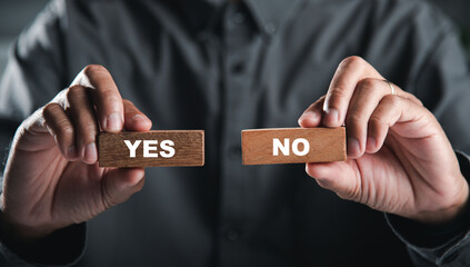Hands of businessman holding wooden blocks with yes and no words portraying decision-making. Choice symbolizes business success. Think With Yes Or No Choice. - obrazy, fototapety, plakaty
