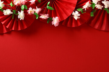 Chinese New Year 2024 red background with folding paper fans and sakura. Top view Lunar New Year...