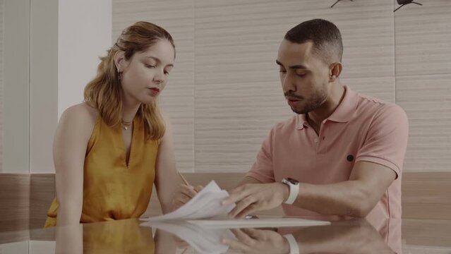 Casal, sentado a mesa, discutindo. Assinando um documento. Cinematico 4k.