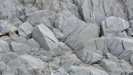 Grauer Felsbeschaffenheitshintergrund. dunkelgraue raue Bergoberfläche mit Rissen. Strukturierter weißer schwarzer Steinhintergrund mit Platz für Design