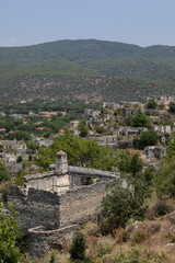 Abandoned Village of Kayakoy are many deserted stone houses with empty windows, without roofs, damaged stone walls. Dead city looks like ancient ruins