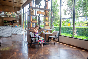 Modern cafe ambiance with individual examining menu book, dressed in colorful attire, surrounded by...