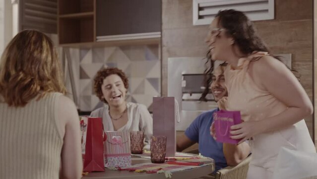 Grupo de pessoas reunidas em casa, se divertindo, brincando de amigo secreto. Cinematico 4k.