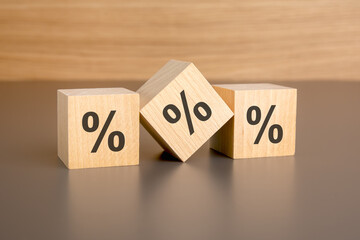 percent sign on wooden cubes against brown background with copy space. concept of sale and discount.