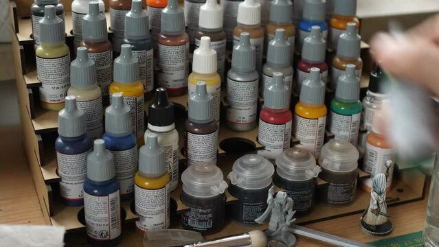 taking paint bottle from stand painting minis, miniatures for rpg game