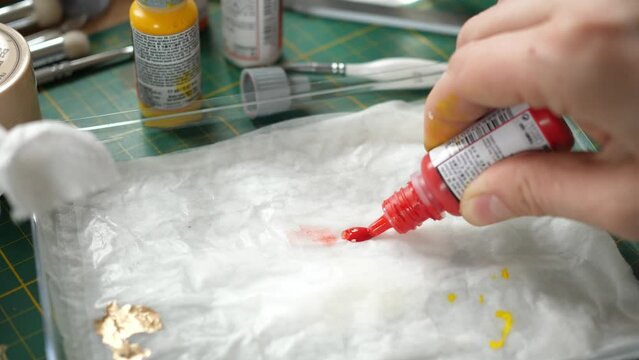squeezing red paint onto a wet palette, painting minis, miniatures for rpg game