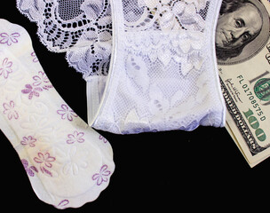 Women's panties, a condom and money. Fornication and prostitution