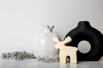 Christmas winter decoration on a white background. Toy candle deer with Christmas tree on top,...