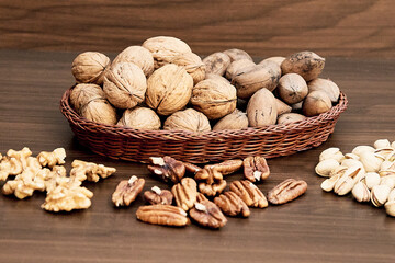 Nutritious combination of walnuts, pecans and pistachios, on a brown table