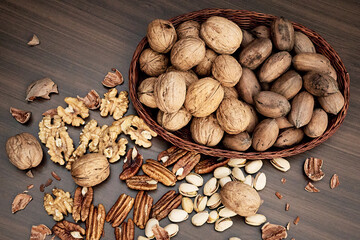 Nutritious combination of walnuts, pecans and pistachios, on a brown table
