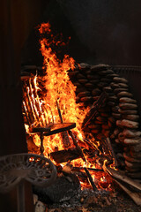 Burning and on fire wooden chair and trash in outdoor burn pit