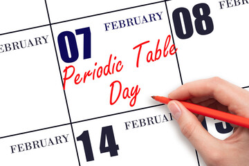 February 7. Hand writing text Periodic Table Day on calendar date. Save the date.