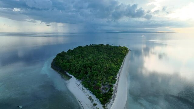 A serene sunrise illuminates the remote island of Koon near Seram, Indonesia. This scenic island's coral reefs, and the surrounding seas, support extraordinary marine biodiversity.