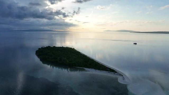 A serene sunrise illuminates the remote island of Koon near Seram, Indonesia. This scenic island's coral reefs, and the surrounding seas, support extraordinary marine biodiversity.