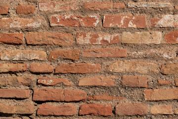 Obraz premium Detail of a section of a worn and weathered, red, brick wall
