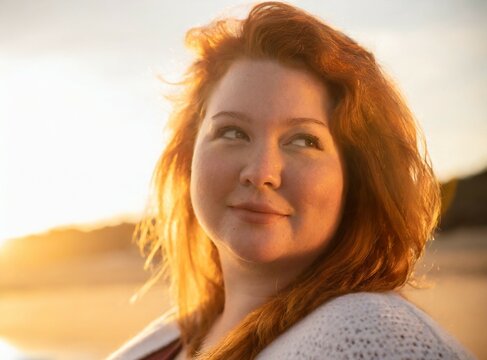 Curvy redhead model on the beach