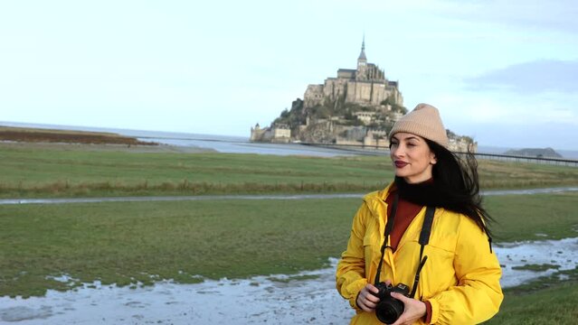 tourist woman walks with her camera through the saint michel valley photographing monuments