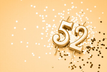 52 years celebration festive background made with golden candle in the form of number fifty-two...
