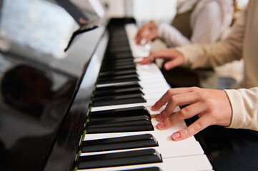 Close-up of kid's hands playing piano.