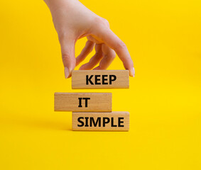 Keep it Simple symbol. Concept words Keep it Simple on wooden blocks. Businessman hand. Beautiful...
