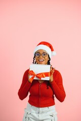 Fototapeta na wymiar Young african Santa woman in Christmas hat hold present box with gift. Happy New Year holiday concept