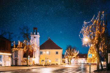 Kuressaare, Estonia. Building Of Fire Bell Tower And Kuressaare Town Hall In Evening Christmas Xmas New Year Illuminations. Amazing Bold Bright Blue Starry Sky Gradient Above Fire Bell Tower.