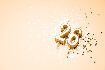 26 years celebration festive background made with golden candle in the form of number Twenty-six lying on sparkles. Universal holiday banner with copy space.