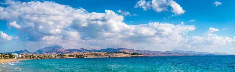 Tranquil coastal landscape with clear blue sky and peaceful ocean water.