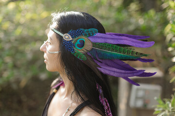 Traditional Indian feather headdress on head of brunette woman with long hair. Ethnic elements.
