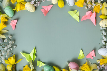 Spring flowers ans easter eggs border on green background with copy space. Easter greeting card...