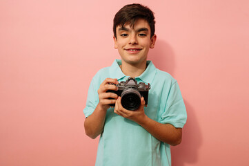 Teen boy with photo camera in the studio.