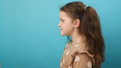 Profile side view of cute little girl child do deep breath enjoy fresh air or dreaming fill with energy feeling healthy good concept, posing isolated over plain blue studio background with copy space