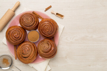 Sweet homemade cinnamon rolls on wooden background, top view