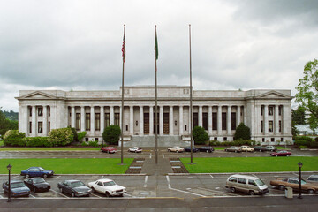 Grainy archival film photograph of the Washington State Supreme Court Building with rainy sky. ...
