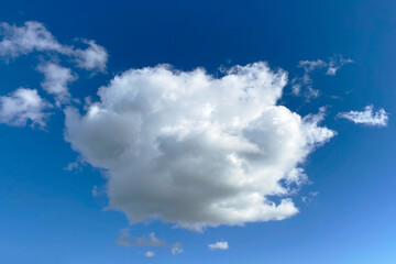 White clouds in the blue sky background. Cloudscape. White fluffy clouds in the blue sky.