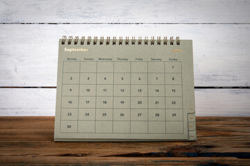 SEPTEMBER 2024 cardboard desk calendar and planner on a wooden texture table