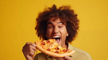 Schilderijen op glas candid studio shot of A hungry man biting a delicious pizza . isolated on vibrant  yellow background with copy space. advertising concept for pizzeria, food delivery, fast food restaurant © ALL YOU NEED studio