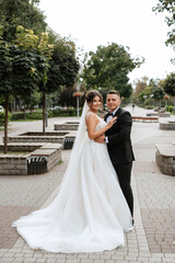 the groom in a brown suit and the bride in a white dress