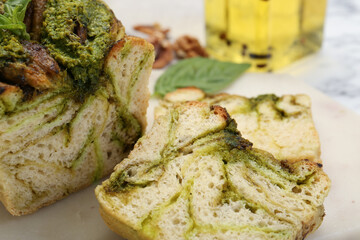 Freshly baked pesto bread on white table, closeup